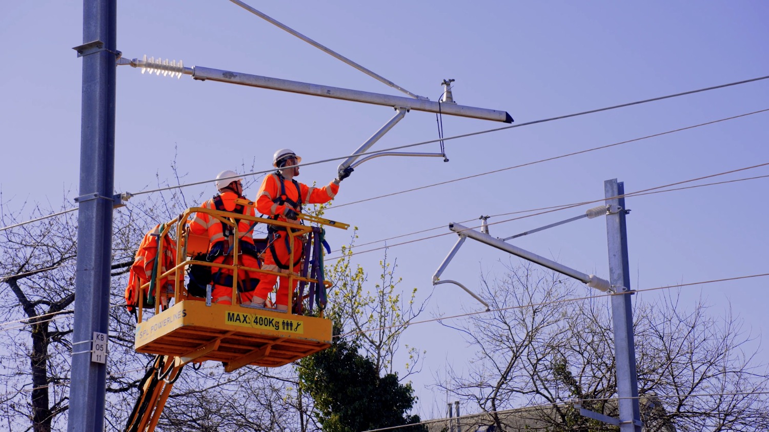 Engineers install overhead wires on railway line